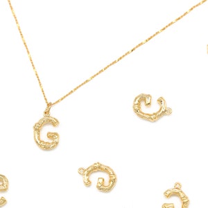 May include: Gold necklace with a letter G pendant and several loose letter G charms. The letter G is made of a textured, bamboo-like design.