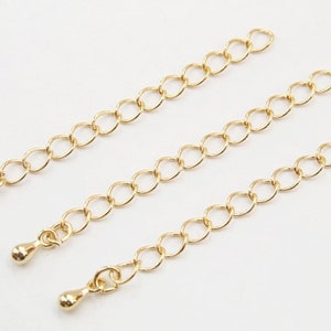 Puede incluir: Tres extensores de cadena dorados con pequeños extremos de bola redonda. Las cadenas están hechas de pequeños círculos unidos.