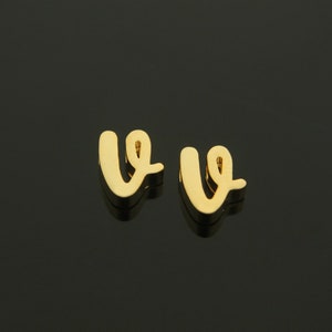 Könnte beinhalten: Ein Paar goldfarbene Ohrringe in Form des Buchstabens "v".
