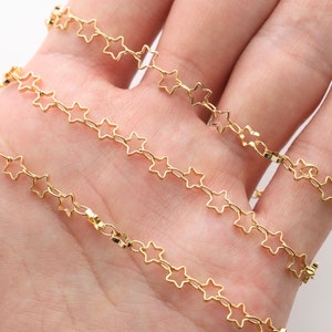 Op de afbeelding: Gouden sterketting, een delicate ketting met kleine stervormige schakels. De ketting wordt getoond in een hand, met meerdere strengen van de ketting.