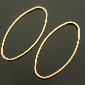 May include: A pair of gold oval hoop earrings. The earrings are simple and elegant, and would be a great addition to any jewelry collection.