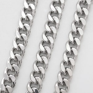 Puede incluir: Tres cadenas de curb plateadas de diferentes longitudes, dispuestas sobre un fondo blanco.