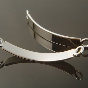 Op de afbeelding: Twee zilveren metalen armband eindkappen met een gebogen vorm en een ronde lus aan elk uiteinde.