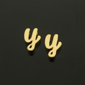 May include: Two gold-colored letter charms in the shape of the letter "y". The charms are in a cursive font.