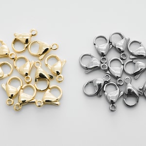 以下が含まれることがあります： ロブスタークラスプの2つのグループのクローズアップ。1つのグループはゴールド、もう1つのグループはシルバーです。クラスプは円形に配置されています。