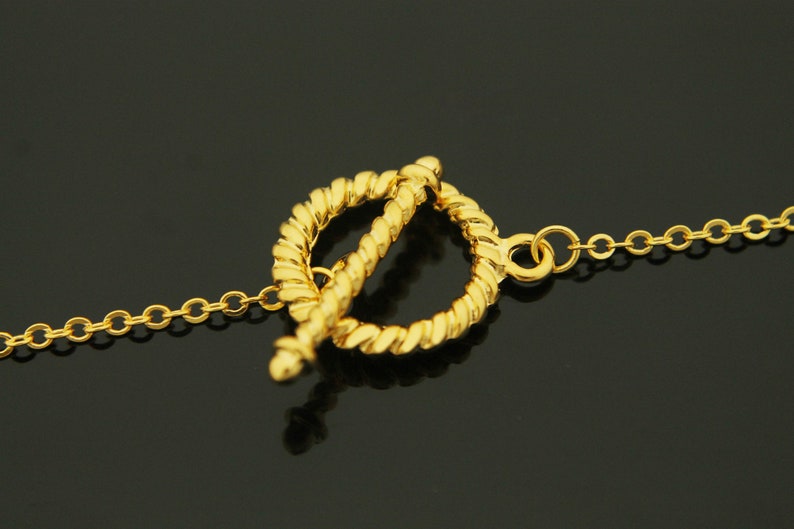 Puede incluir: Un collar de cadena de oro con un cierre de estilo cuerda trenzada. El cierre es un c&iacute;rculo con un c&iacute;rculo m&aacute;s peque&ntilde;o que se desliza a trav&eacute;s de &eacute;l.