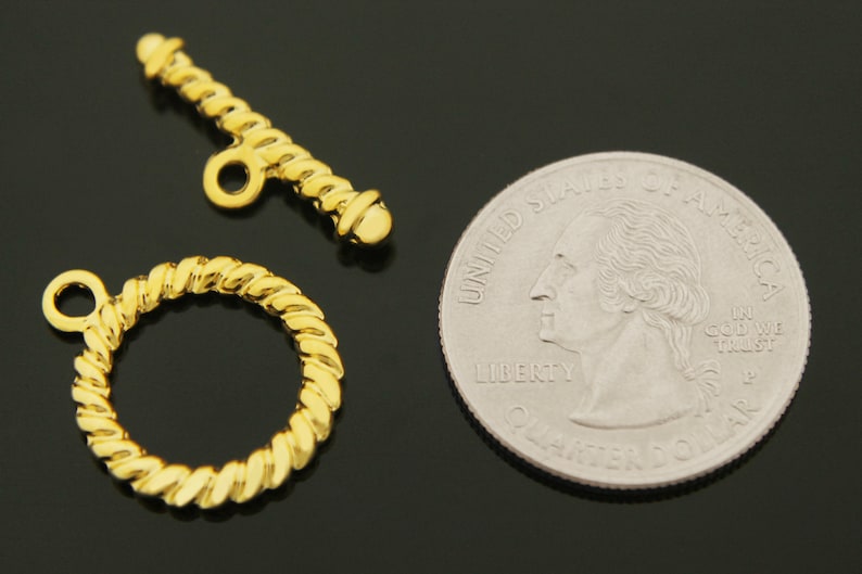 Puede incluir: Cierre de bot&oacute;n de metal dorado con un dise&ntilde;o de cuerda. El cierre es aproximadamente del tama&ntilde;o de una moneda de 25 centavos de d&oacute;lar estadounidense.