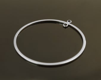 May include: A silver hoop earring with a small, three-pronged attachment at the top.