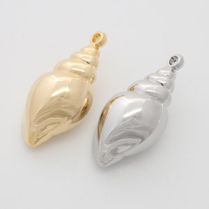 May include: Two seashell charms, one gold and one silver, with a detailed spiral design. These charms are perfect for adding a touch of coastal style to jewellery.