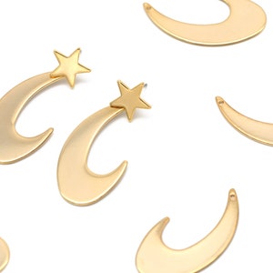 May include: A pair of gold crescent moon earrings with a star charm on each earring.