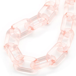 May include: A pink plastic chain necklace with large, rectangular links.