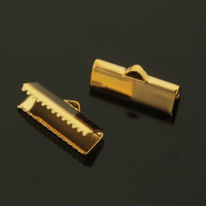 May include: Two gold metal clasps for jewellery making. The clasps are rectangular and have a smooth finish.