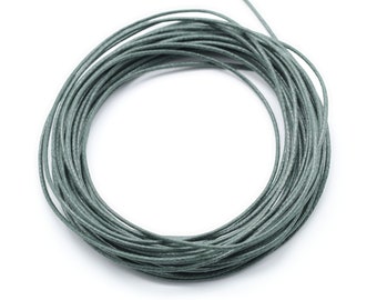 May include: A spool of sage green waxed cotton cord. The cord is wound tightly in a circle.