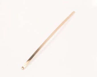 May include: A long, thin, gold-colored metal hair stick.