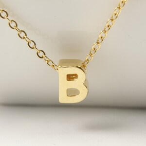 May include: A gold chain necklace with a gold letter 'B' pendant.