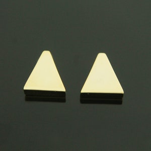 May include: A pair of gold triangle shaped earrings.