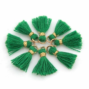 May include: Eight green tassels with gold accents and a gold ring attached to each tassel.