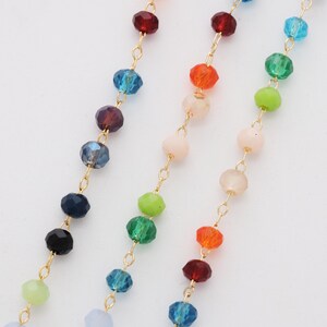 May include: Close-up of three strands of colorful beaded jewelry. Each strand features a different color palette of faceted beads strung on a delicate gold chain. The beads are in shades of red, orange, yellow, green, blue, and purple.