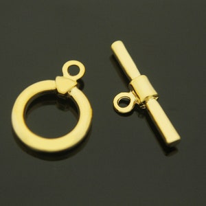 Pu&ograve; includere: Chiusura a scatto in metallo dorato con un anello rotondo e una barra con un anello ad un'estremit&agrave;. La chiusura &egrave; utilizzata per la creazione di gioielli.