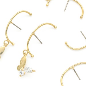 May include: Five gold-tone earring findings with butterfly charms. Each finding has a curved wire with a small ball at the end and a post for an earring.
