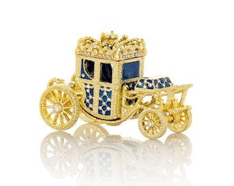 Puede incluir: Un carruaje dorado con detalles azules y blancos, decorado con diamantes de imitación. El carruaje es un adorno decorativo.