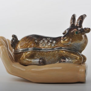 Portagioie in stile Fabergé con ariete dello zodiaco adagiato sulla mano, realizzato a mano da Keren Kopal, dipinto a smalto e decorato con cristalli Swarovski.