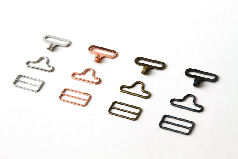 May include: Four sets of metal clasps for sewing projects. Each set includes a hook and a slider. The clasps are available in silver, rose gold, brass, and black.