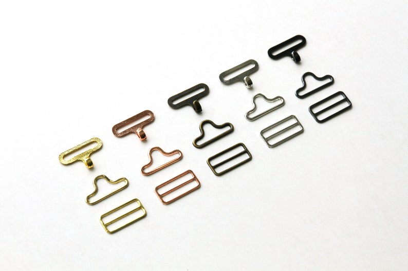May include: Five sets of metal clasps in different finishes: gold, copper, silver, black, and gunmetal. Each set includes a hook, a D-ring, and a slider.