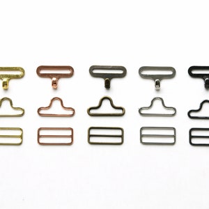 May include: Five sets of metal clasps in different finishes: gold, rose gold, antique brass, silver, and black. Each set includes a top clasp, a bottom clasp, and a slider.