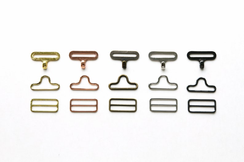 May include: Five sets of metal clasps in different finishes: gold, rose gold, antique brass, silver, and black. Each set includes a top clasp, a bottom clasp, and a slider.