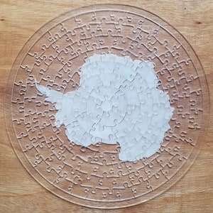 Transparente Antarktis Rundpuzzle: Herausforderndes Acrylpuzzle mit weißer Gravur für Geographie-Begeisterte