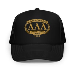 Puede incluir: Gorra de camionero negra con un logotipo bordado en oro que dice "Adam's College", "ΛΛΛ", "Lamba Lambda Lamda" y "1984".