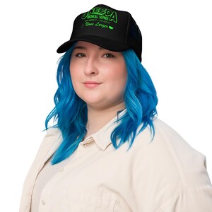 May include: A black trucker hat with a green logo that says "Uneeda Medical Supply" and "You Need It - We Got It - Now Larger".