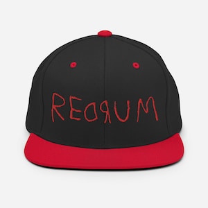 Puede incluir: Gorra de béisbol negra y roja con la palabra "REDRUM" escrita en rojo en la parte delantera.