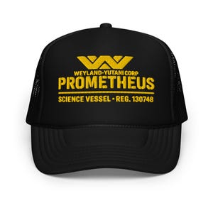 以下が含まれることがあります： 黄色いロゴとテキストが入った黒いトラッカーハット。テキストは「WEYLAND-YUTANI CORP PROMETHEUS SCIENCE VESSEL REG. 130748」と書かれています。帽子はメッシュバックと湾曲したつばが付いています。