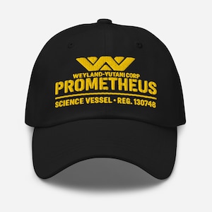 May include: Black baseball cap featuring yellow embroidered text: "WEYLAND-YUTANI CORP PROMETHEUS SCIENCE VESSEL REG. 130748". The cap has a curved peak and a button on the crown.