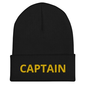 May include: Black beanie with a gold embroidered word "CAPTAIN" on the front.
