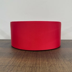 May include: A roll of bright red satin ribbon.