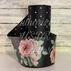May include: Black and white polka dot ribbon with a black ribbon with pink roses and glitter.