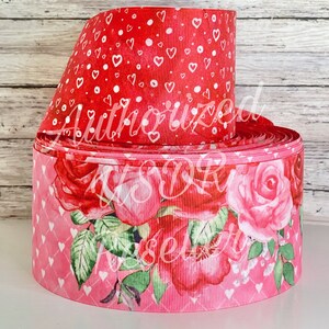 May include: Two rolls of pink and red ribbon with a floral and heart pattern. The ribbon is 2.5 inches wide.
