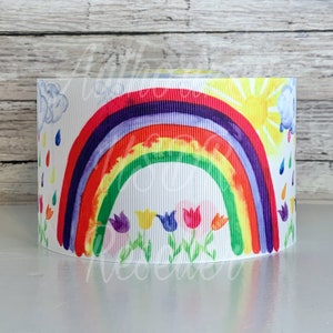 May include: White ribbon with a colorful rainbow, sun, clouds, raindrops, and flowers printed on it.