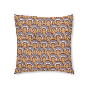 May include: A square throw pillow with a geometric pattern of yellow, orange, blue, and red. The pattern is made up of repeating circles and arches.