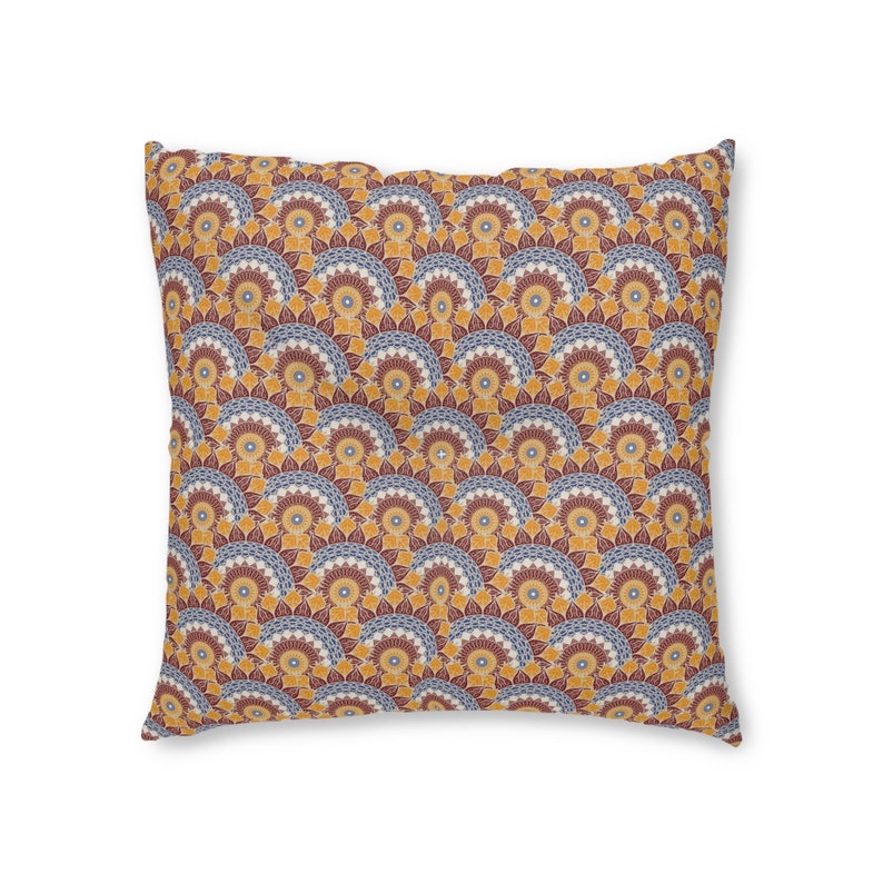 May include: A square throw pillow with a geometric pattern of yellow, orange, blue, and red. The pattern is made up of repeating circles and arches.