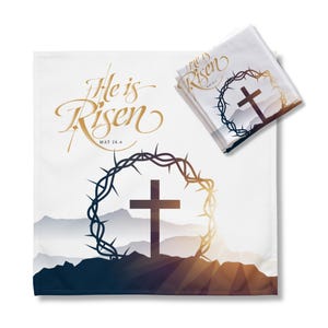 May include: White fabric with a gold inscription "He is Risen" and a cross with a crown of thorns on a mountain landscape. The scripture reference "MAT 28.6" is also included.