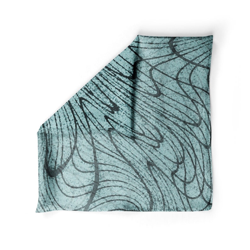May include: A teal blue fabric scarf with a black and white abstract pattern of lines and swirls.