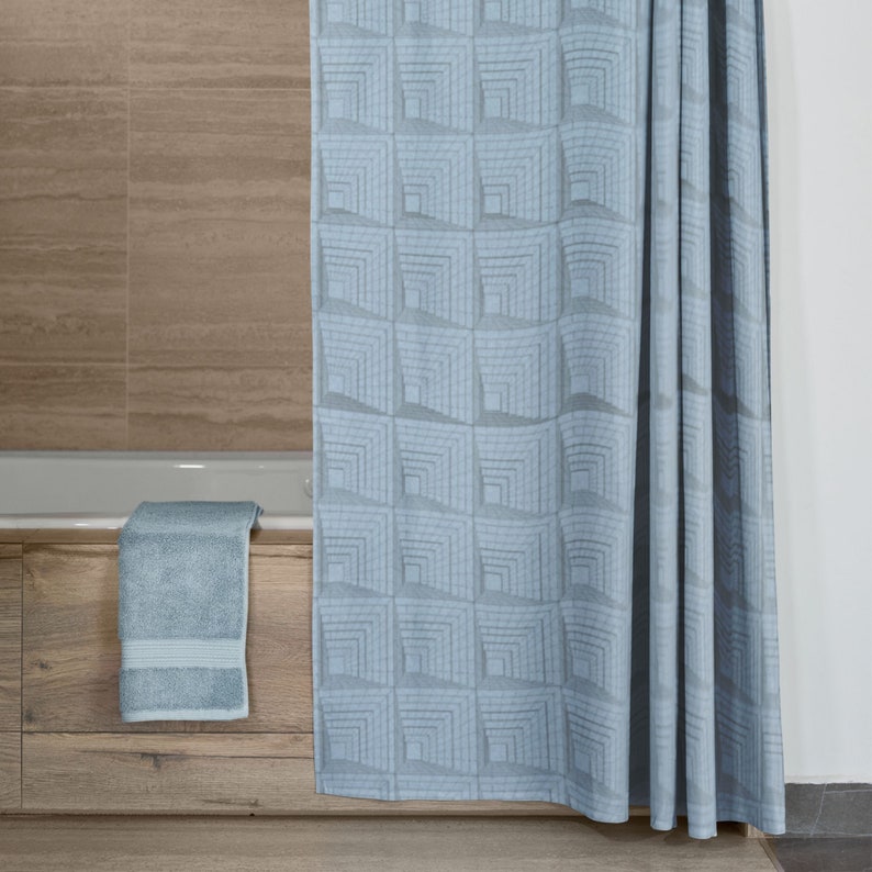 May include: A light blue shower curtain with a geometric pattern of squares. The curtain is hanging in a bathroom with a wooden bathtub and a towel on the edge of the tub.