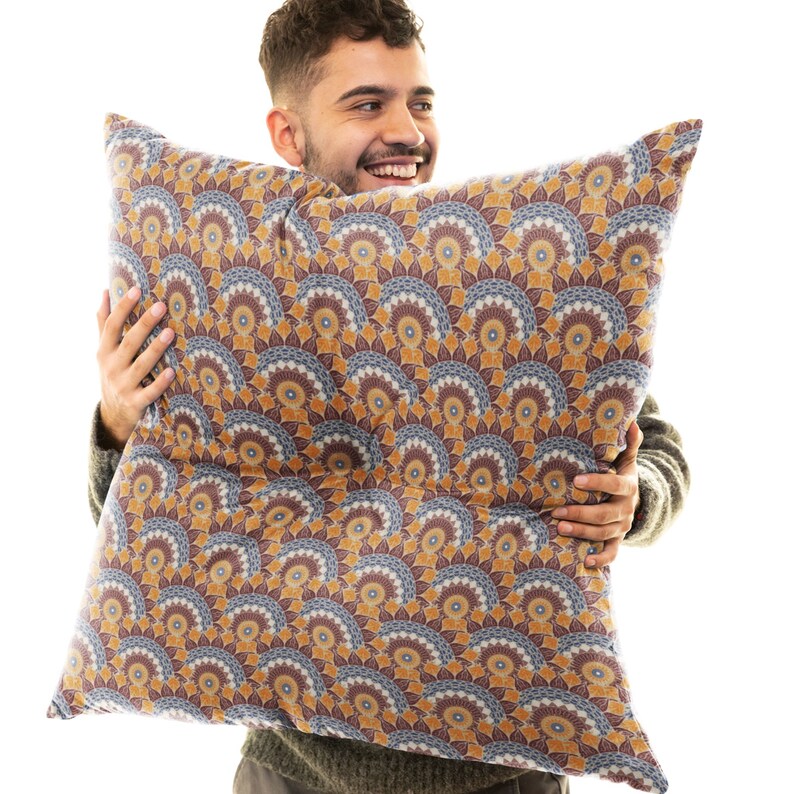 May include: A decorative pillow with a brown, blue, and yellow mandala pattern. The pillow is made of a soft, plush fabric and has a zipper closure.