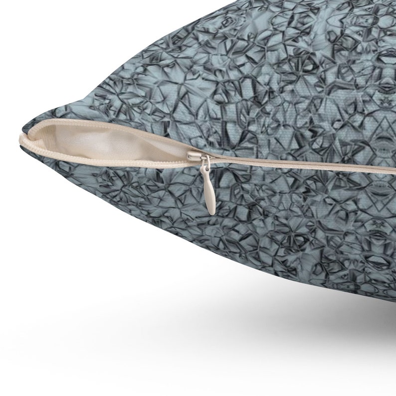 May include: A blue and gray throw pillow with a geometric pattern. The pillow has a zipper closure.