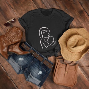 May include: A black t-shirt with a white outline of a mother holding a baby. The text '#momlife' is below the image.