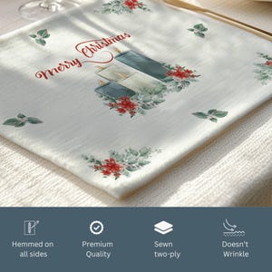 Może przedstawiać: Biały świąteczny podkład pod talerz z napisem "Merry Christmas" w kolorze czerwonym i akwarelową ilustracją trzech świec i zieleni. Podkład jest obszyty ze wszystkich stron i charakteryzuje się wysoką jakością, dwuwarstwową konstrukcją, odporną na zagniecenia.